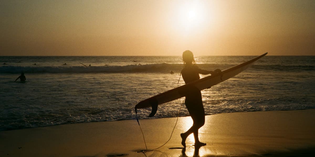 Surfers riding waves at Canggu Bali during sunset session